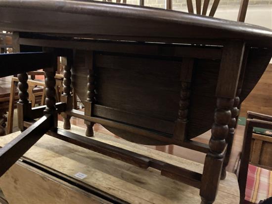 A low oak oval topped gateleg table, width 105cm extended 130cm height 51cm